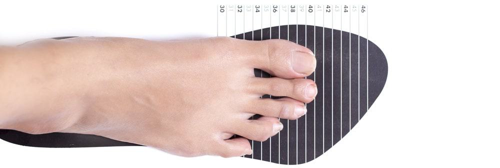 This is a close look at a woman measuring her shoe size.