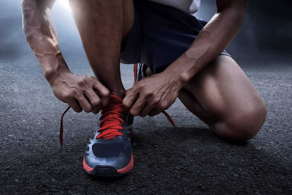 This is a close look at a man tying his running shoes.