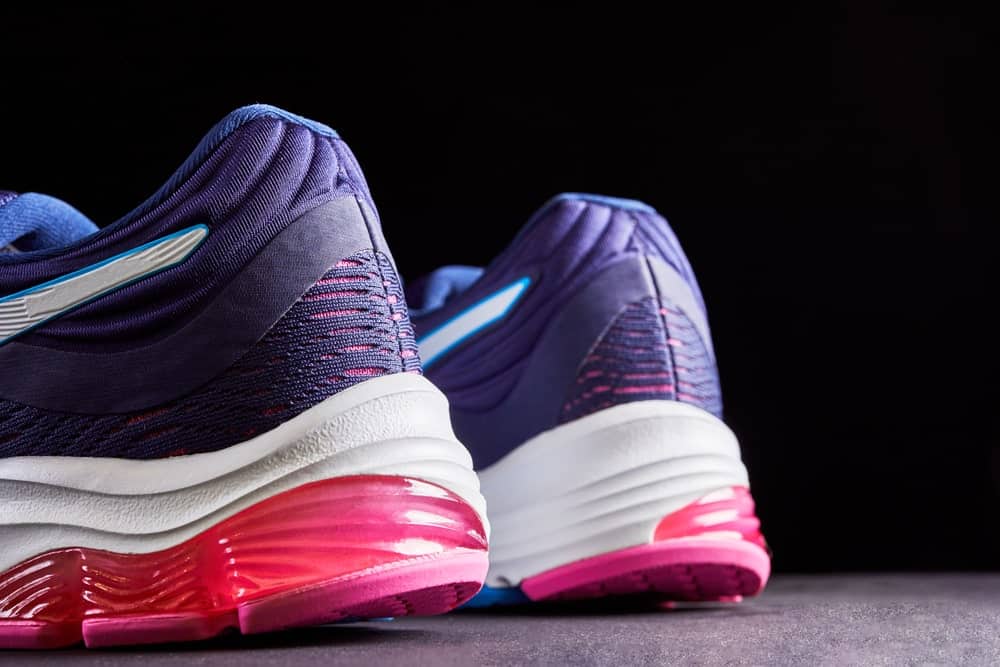 A close look at a pair of purple and pink running shoes.