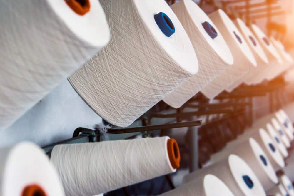 A close look at spools of white cotton thread.