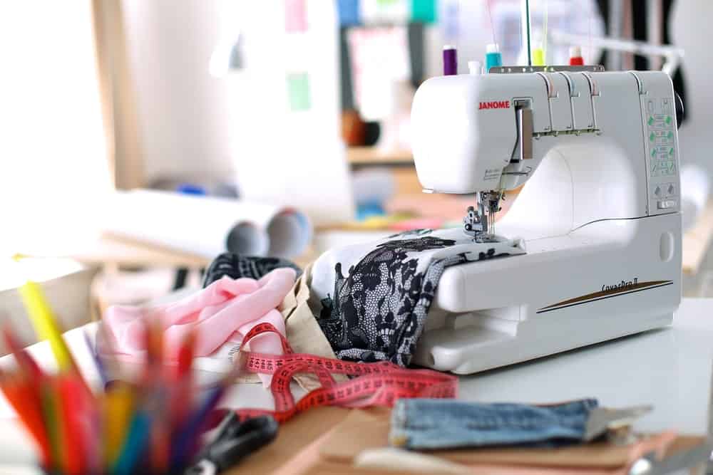 A sewing machine with threads and cloths.