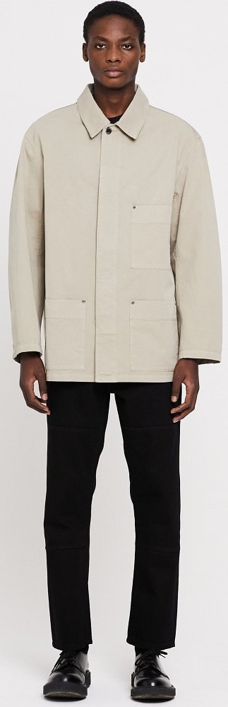 A man wearing the excursion garment dyed beige from Etudes.