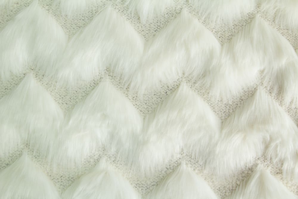 Textured faux fur fabric with long pile.