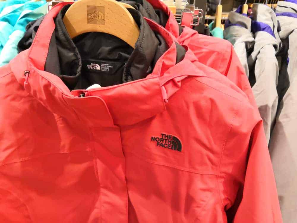 The North Face jackets on hangers in a store.