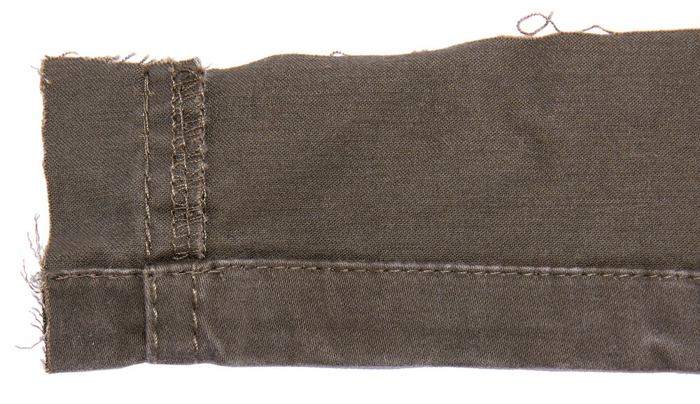 Twill textile showing seam allowance and tattered threads.