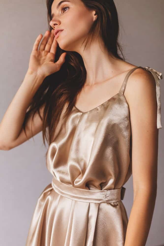 This is a close look at a woman wearing a gold camisole.