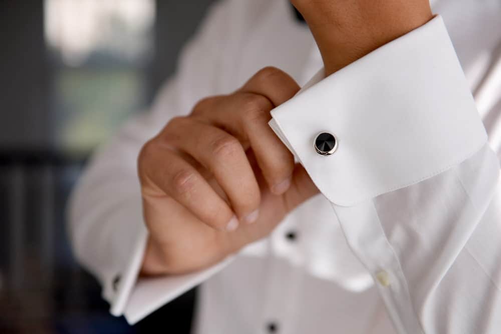 A close look at a man wearing cufflinks on his white cuff.