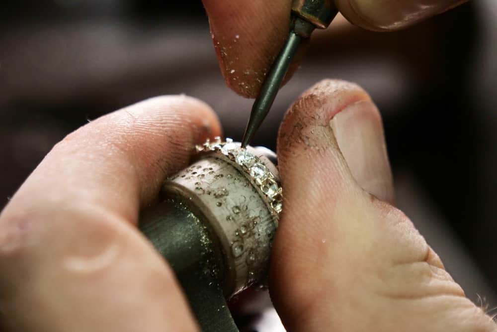 This is a close look at a goldsmith putting in diamonds on a ring.