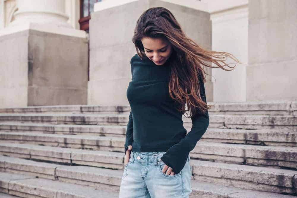 This is a look at a woman wearing jeans with her long-sleeved shirt.