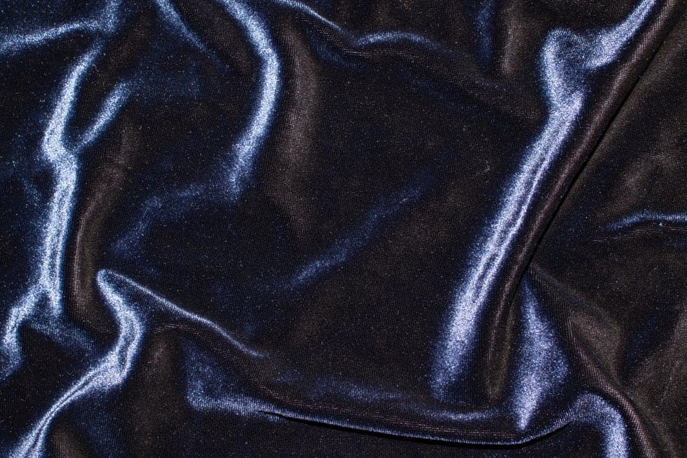 This is a close look at a navy blue stretch velvet fabric.
