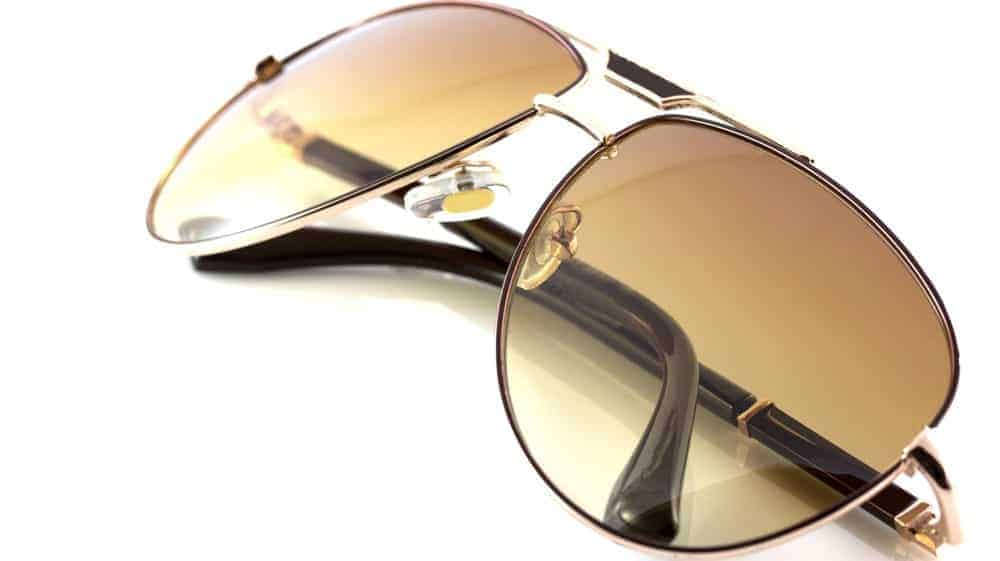 A close look at a pair of sunglasses with metal frames and tinted lenses.