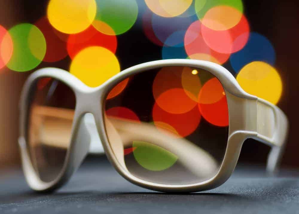 This is a close look at a pair of white sunglasses with plastic lenses.