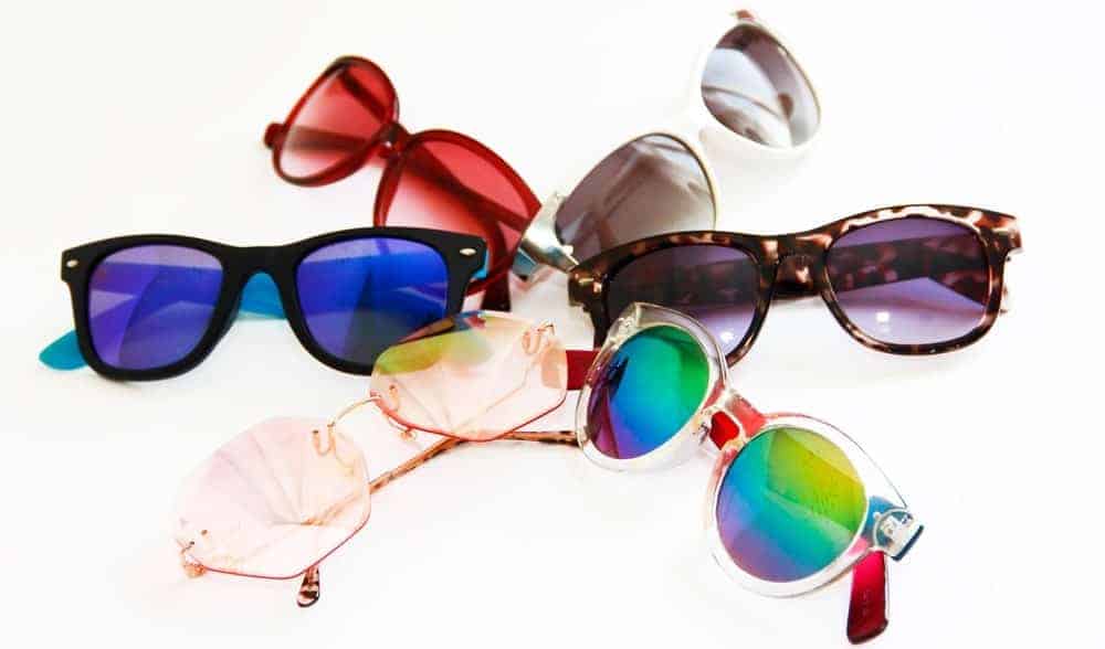 This is a close look at a bunch of various sunglasses with colored lenses.