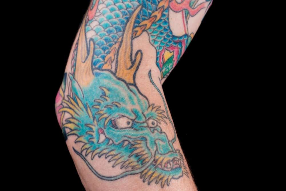 This is a close look at an arm with a detailed Japanese tattoo of a dragon.