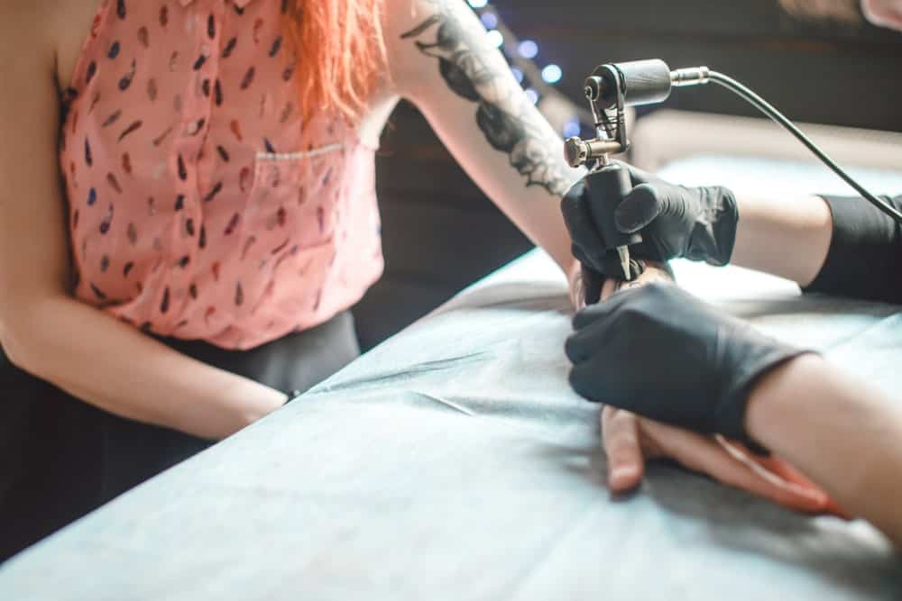 This is a close look at a woman having her left arm tattooed.