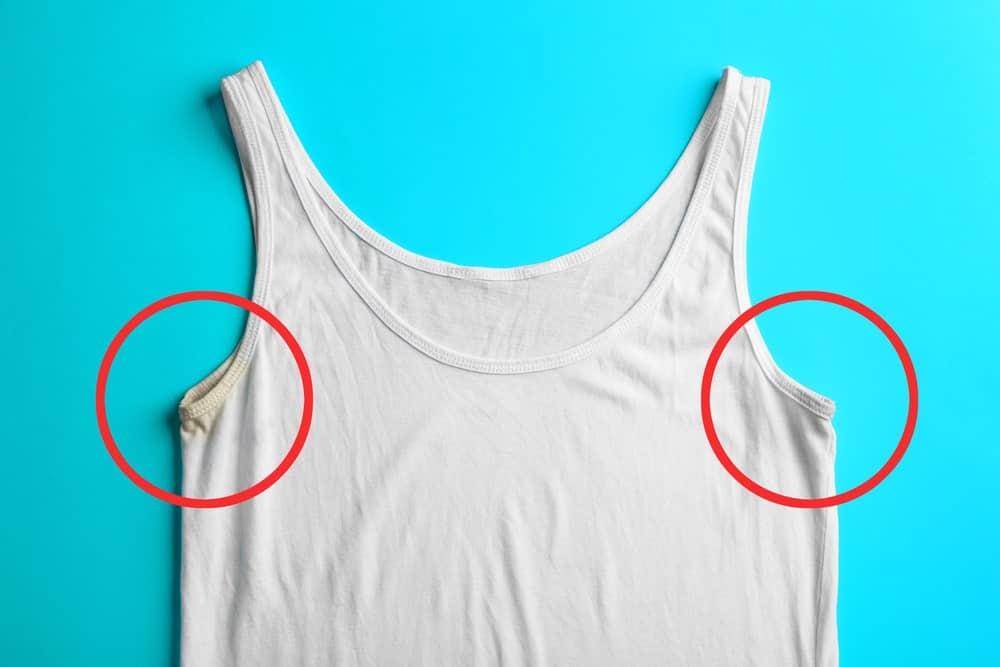 This is a close look at a white tank top undershirt with deodorant pit stains.