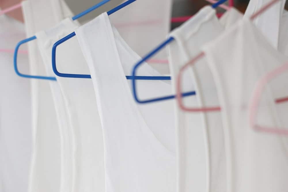 This is a close look at a row of white tank top undershirts on display.