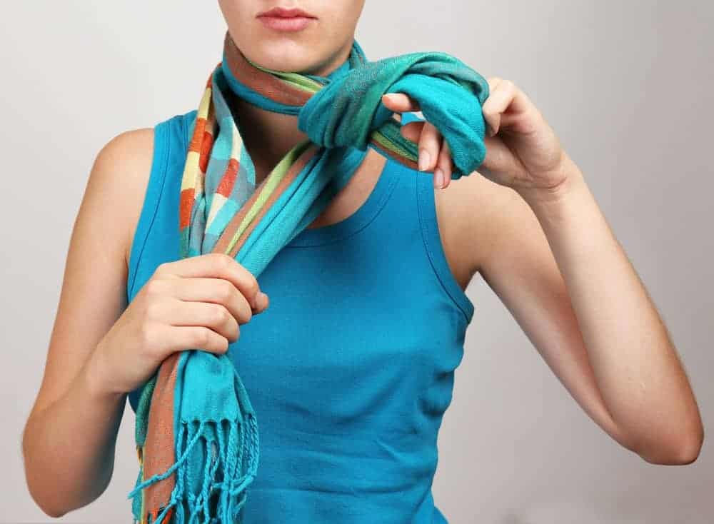 Woman tying a scarf.