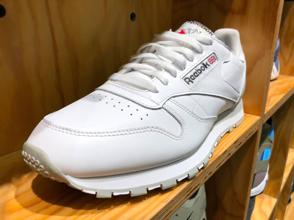 This is a close look at a Reebok sneaker on a shelf on display at a store.