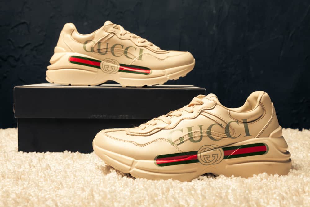 This is a close look at a pair of Gucci sneakers on display.