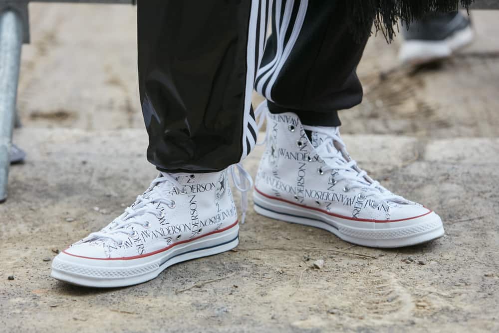 A close look at a man wearing a pair of Fendi white sneakers.