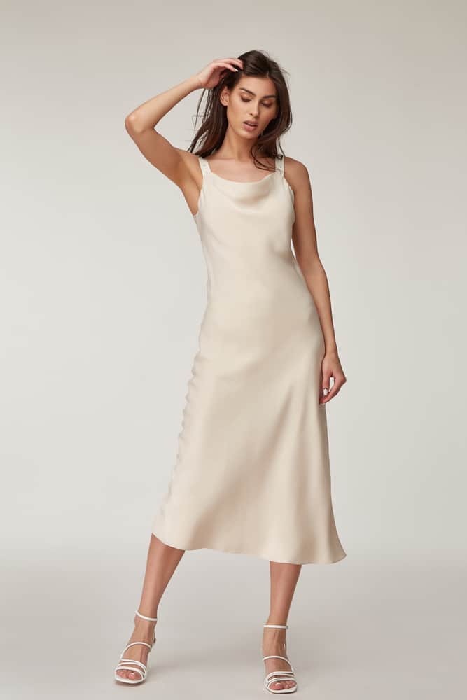 This is a woman wearing a silky beige Midi Dress.