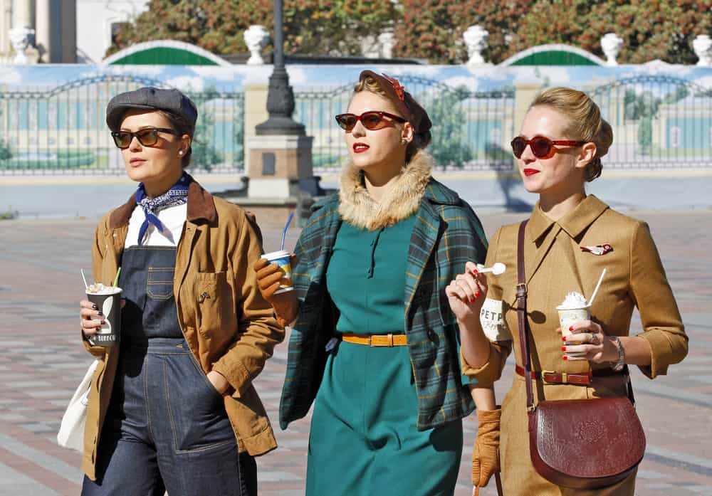 Women dressed in vintage clothes walking on the street.