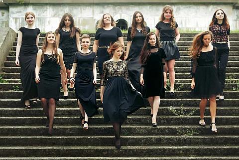A group of women walking down the steps wearing black dresses.