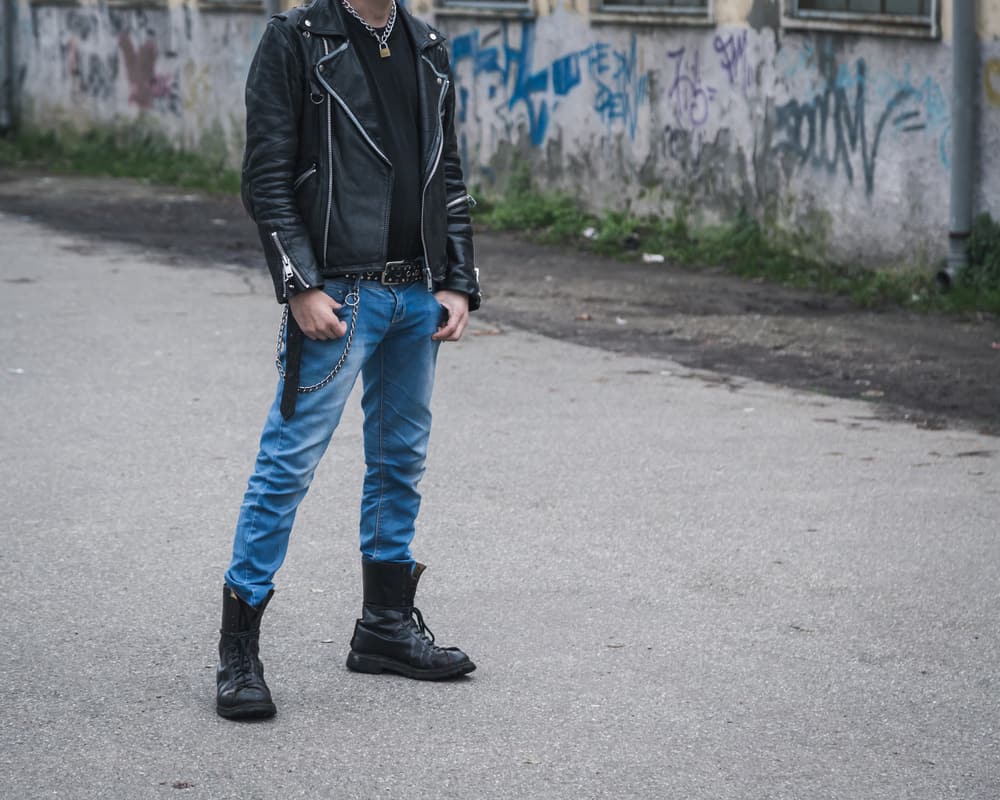 Punk guy wearing leather jacket, denim pants, and boots.