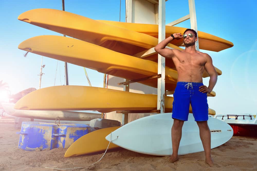A man wearing a pair of blue lifeguard board shorts.