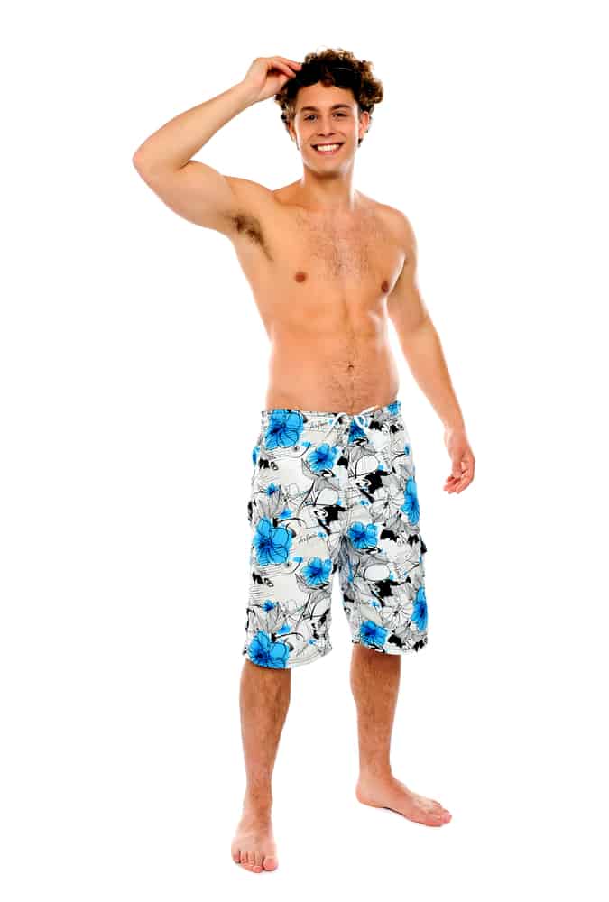 This is a man wearing a pair of floral print swim shorts.