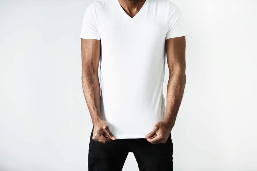 This is a close look at a man wearing a white shirt with his black pants.