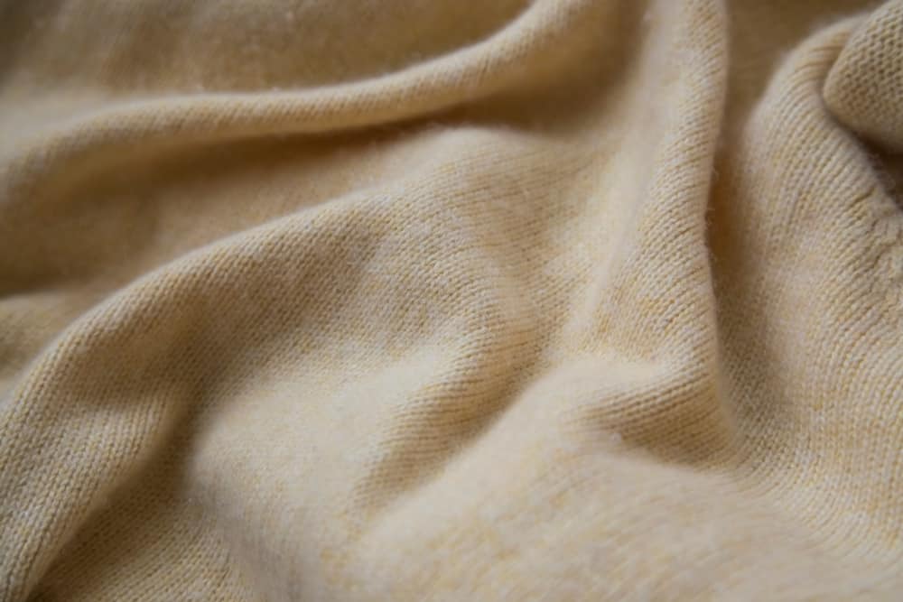 This is a close look at a soft beige cashmere sweater.