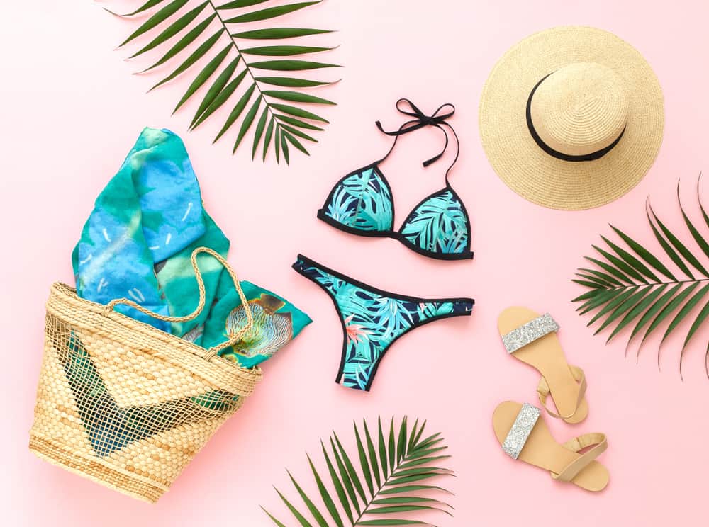 A tropical print bikini surrounded by beach accessories.