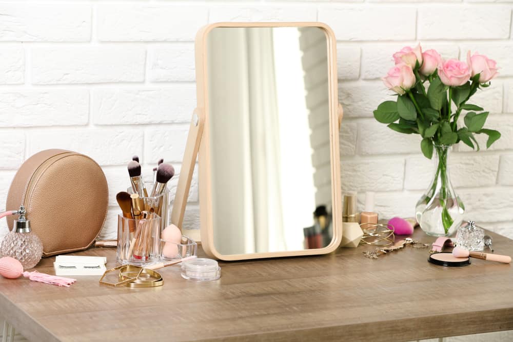 Different makeup products and accessories on a dressing table.