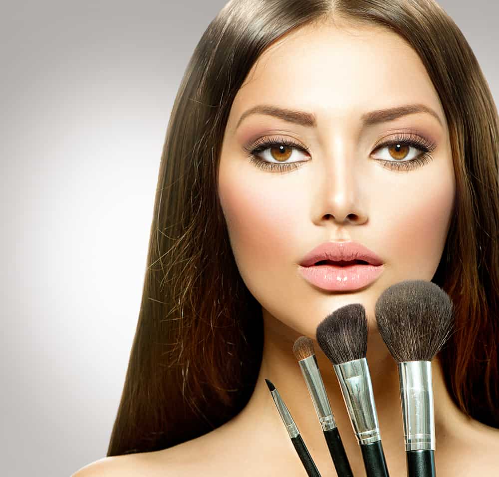 Woman with natural makeup and brushes.