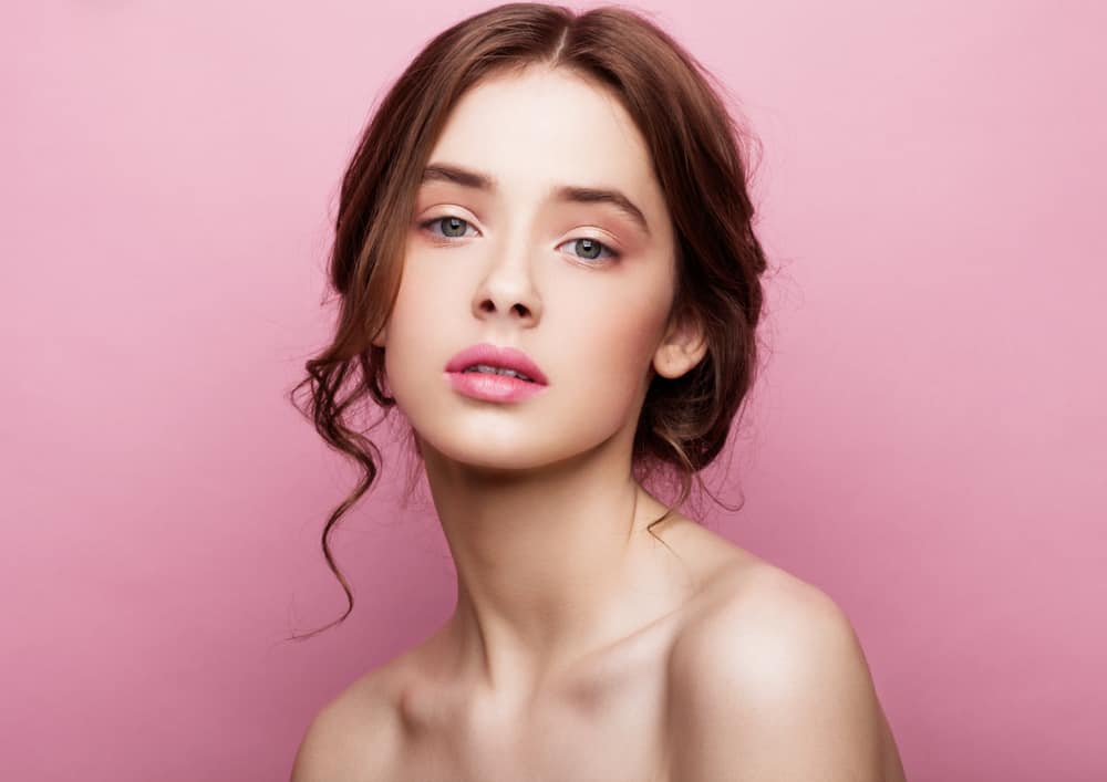 Model with natural make up on pink background.