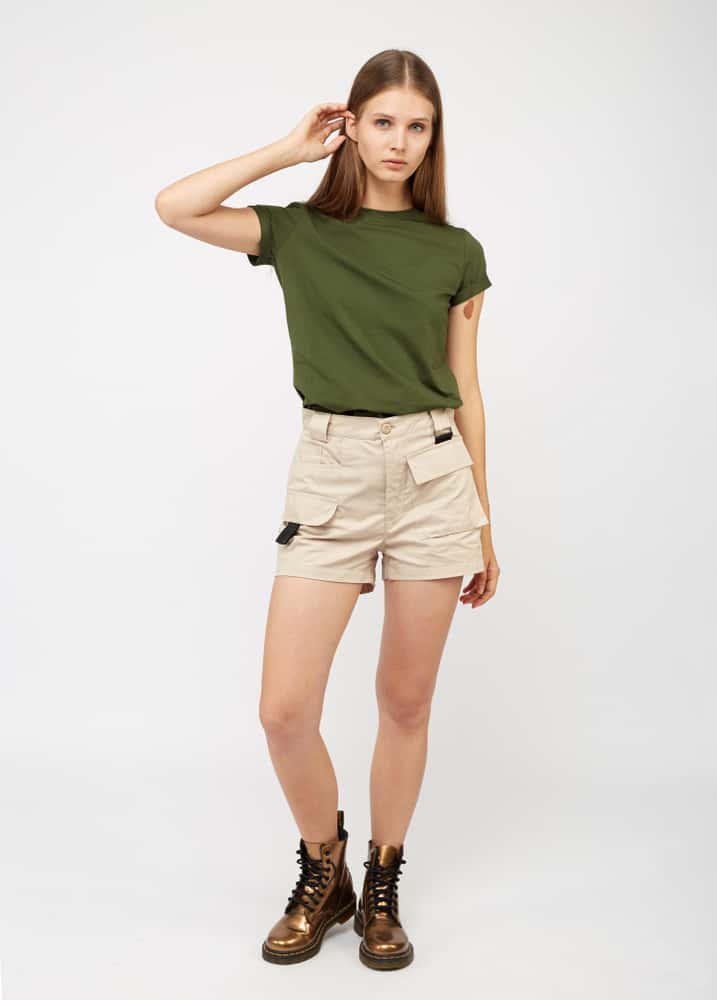 A woman wearing a pair of khaki cargo shorts with a green shirt and boots.