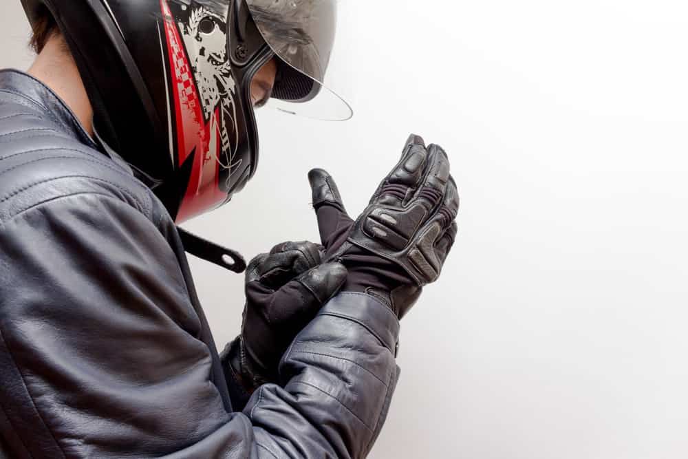 This is a rider putting on his motorcycle gloves.