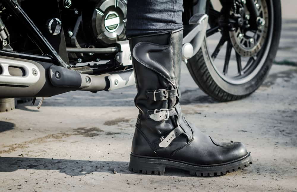 This is a close look at a rider wearing a pair of black leather riding boots.