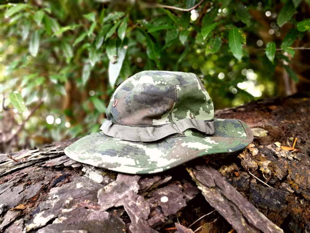 A close look at a camouflage print boonie hat on a tree trunk.