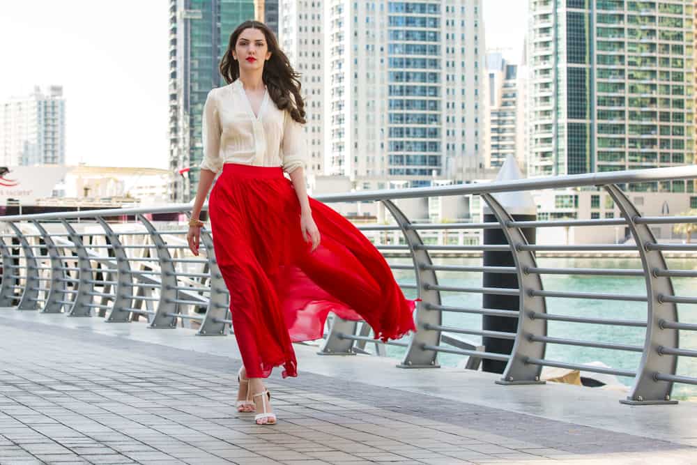A woman wearing red skirt by the bay.