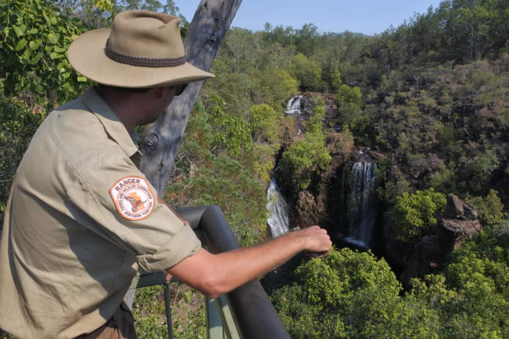 A park ranger looking over the waterfalls in the distance.