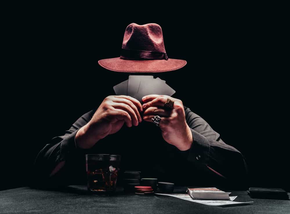 A gambler wearing a gambler hat while gambling.