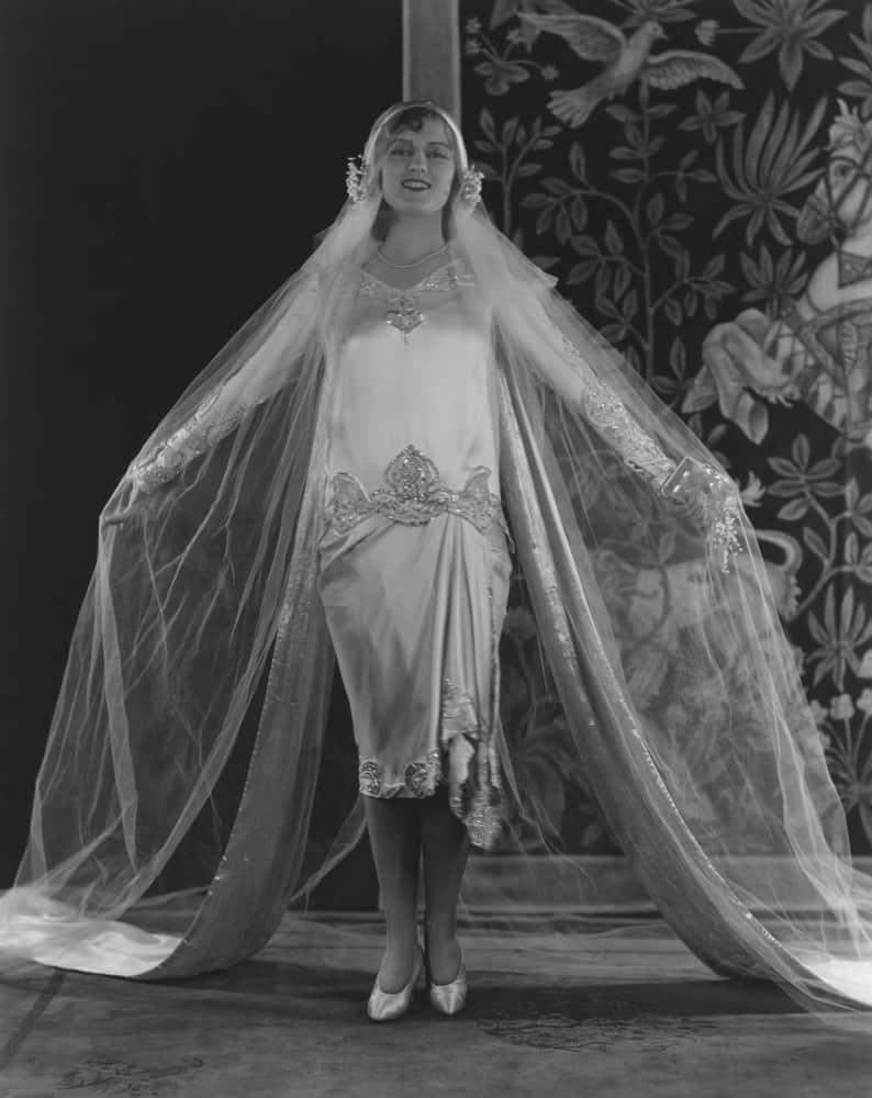 Black and white photo of a young bride in a loose wedding gown.