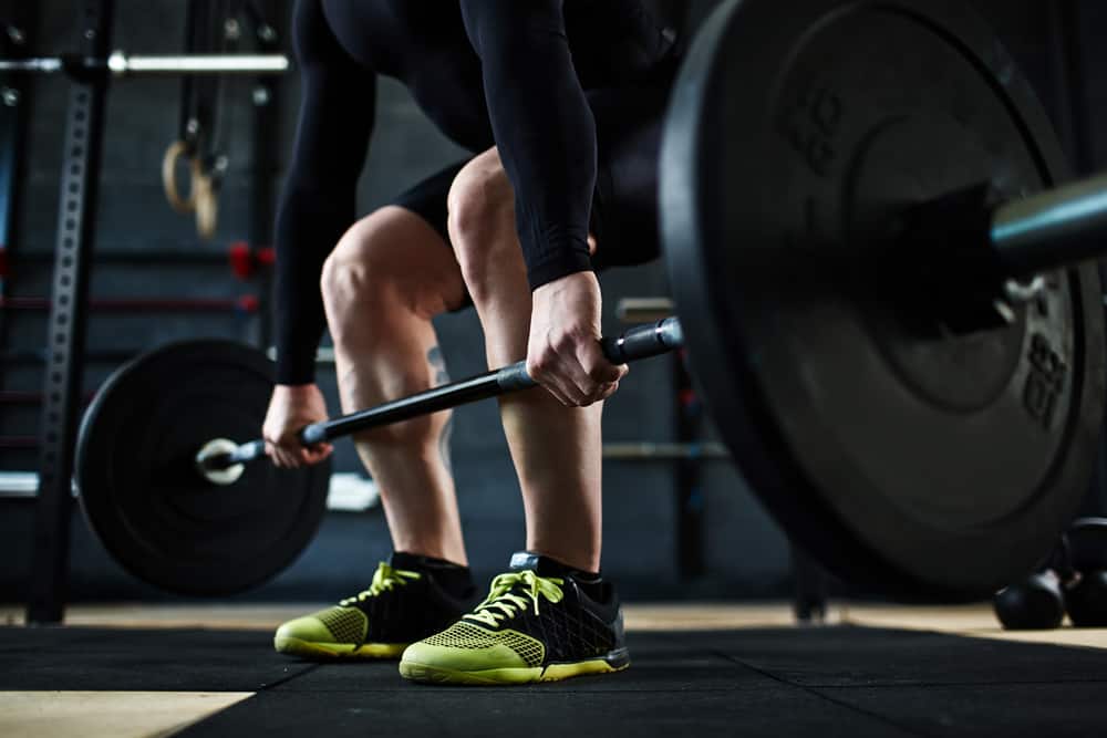 This is a close look at a weightlifter wearing cross training shoes.