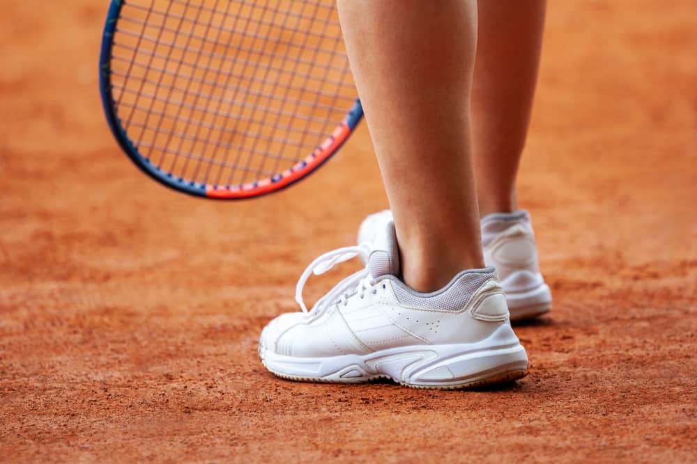 A close look at a tennis player wearing a pair of court shoes.
