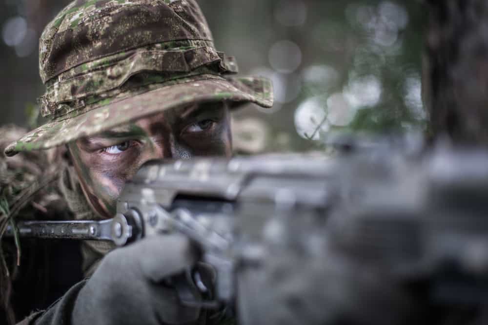 A close look at a soldier in action wearing camouflage.