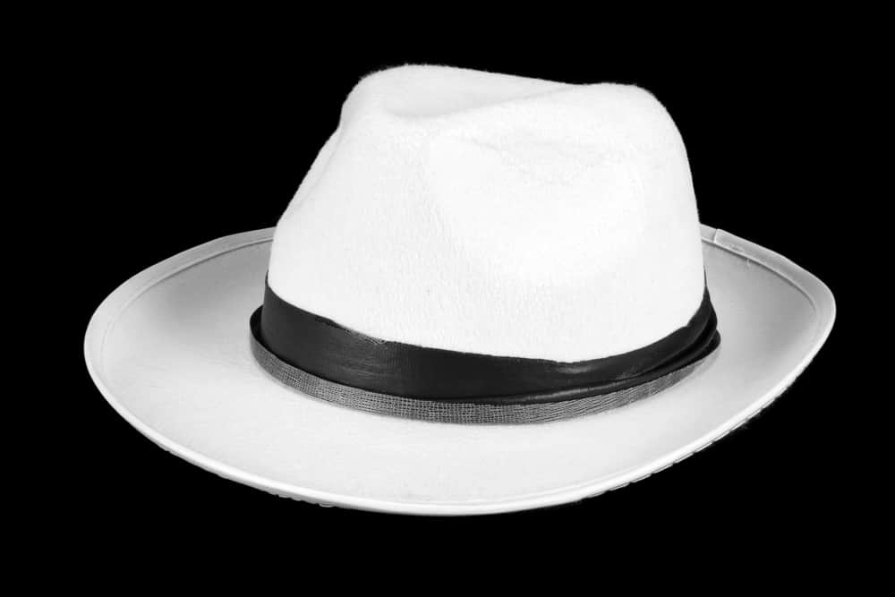 This is a white fedora on a black surface.