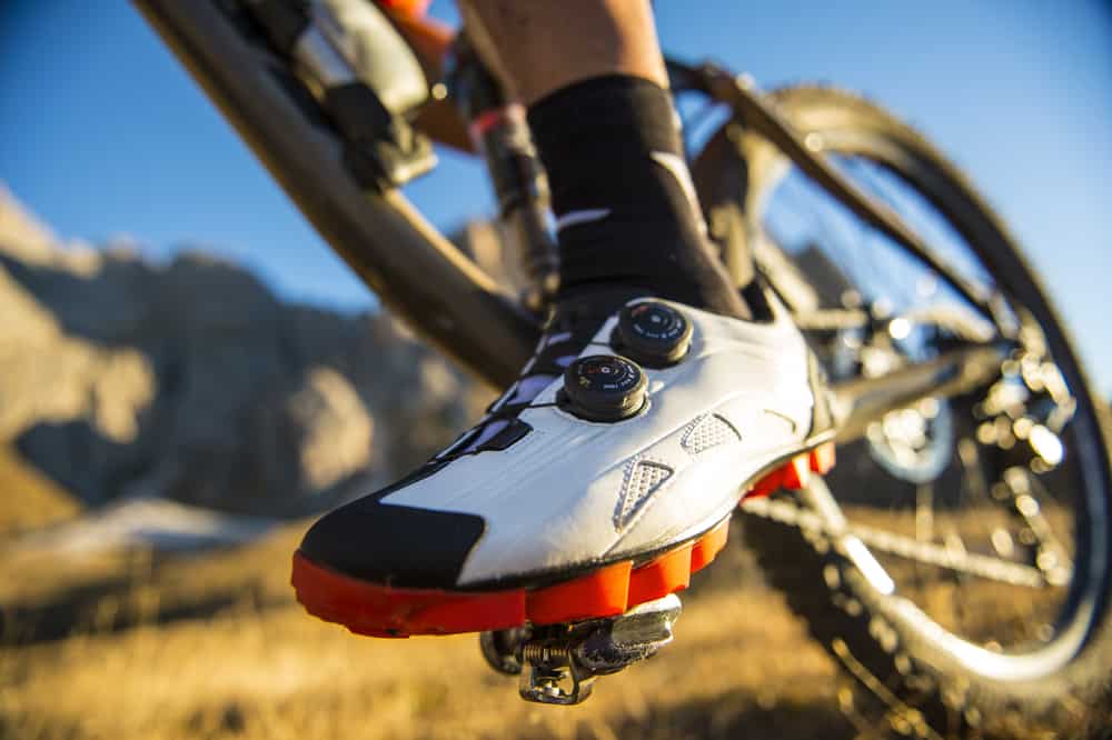 A close look at a cyclist wearing cycling shoes.